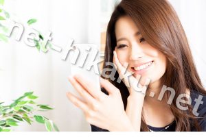 スマホを笑顔で見る女性